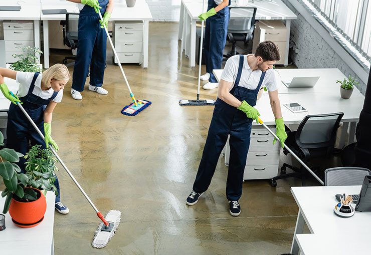 Office cleaning team mopping floor