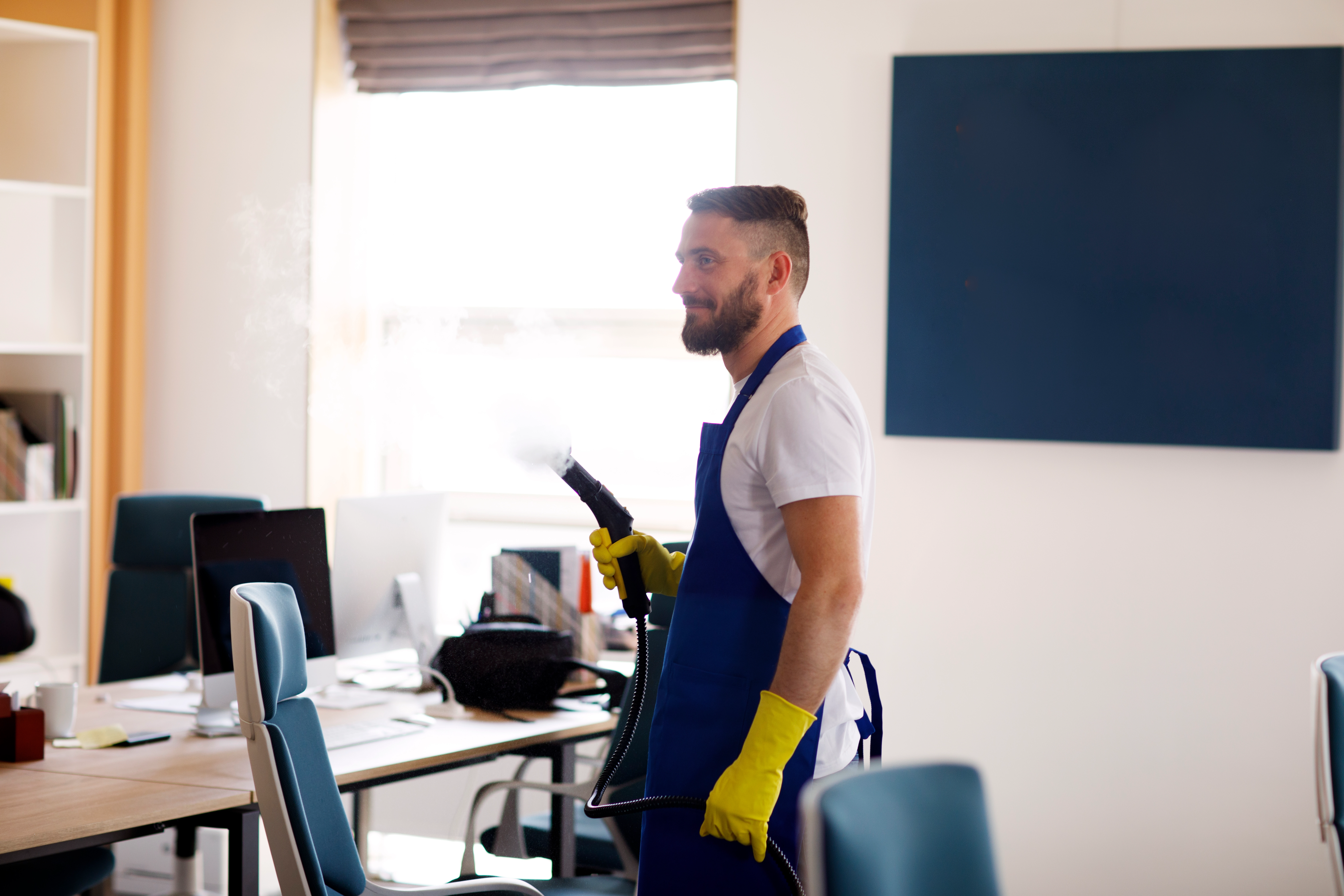 professional cleaning service person using steam cleaner office